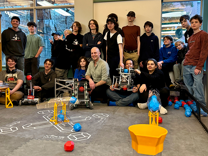 The GISS Cyber/Scorpions robotics team with sponsor Ethan Wilding at the competition field